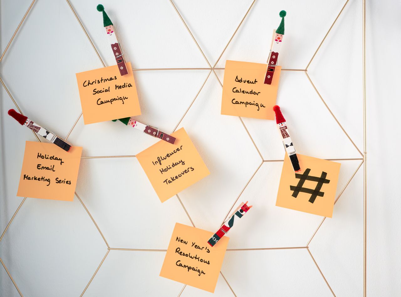 Des post-its portant des idées de marketing pour les fêtes sont fixés sur une grille murale.